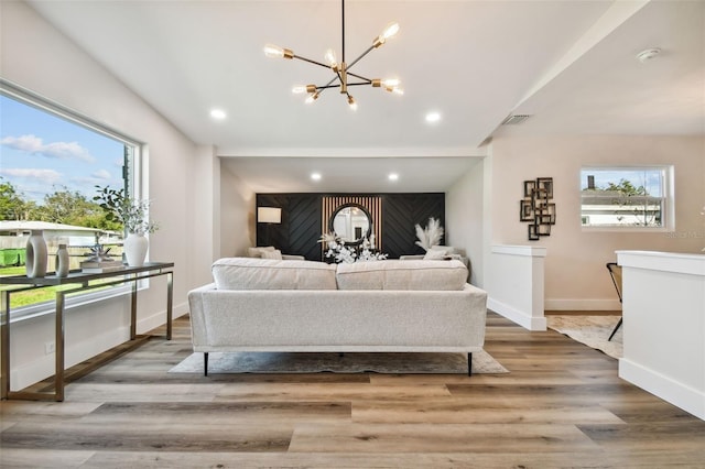 living room featuring hardwood / wood-style flooring, a notable chandelier, and a healthy amount of sunlight