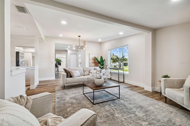 living room featuring dark wood-type flooring and a notable chandelier