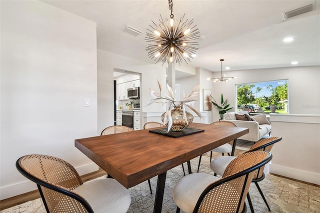 dining area featuring light hardwood / wood-style floors and a notable chandelier