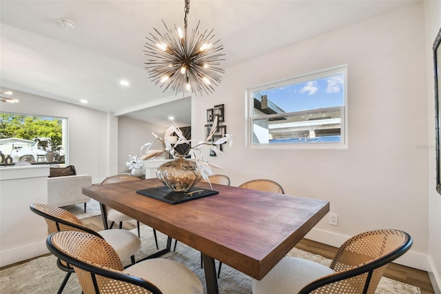 dining room featuring light wood-type flooring, a wealth of natural light, and a notable chandelier