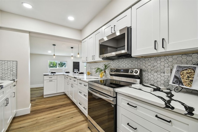 kitchen featuring light hardwood / wood-style flooring, tasteful backsplash, hanging light fixtures, stainless steel appliances, and white cabinetry