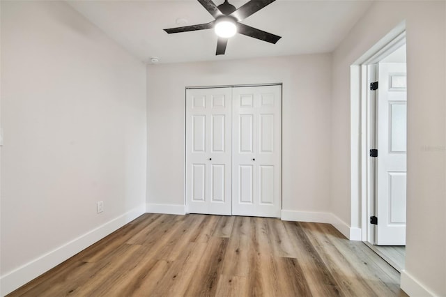 unfurnished bedroom featuring ceiling fan, light hardwood / wood-style floors, and a closet