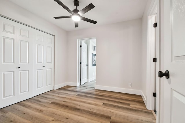 unfurnished bedroom with light hardwood / wood-style flooring, ceiling fan, and a closet