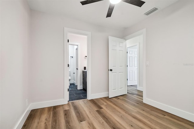 unfurnished bedroom featuring light hardwood / wood-style floors, ensuite bath, and ceiling fan