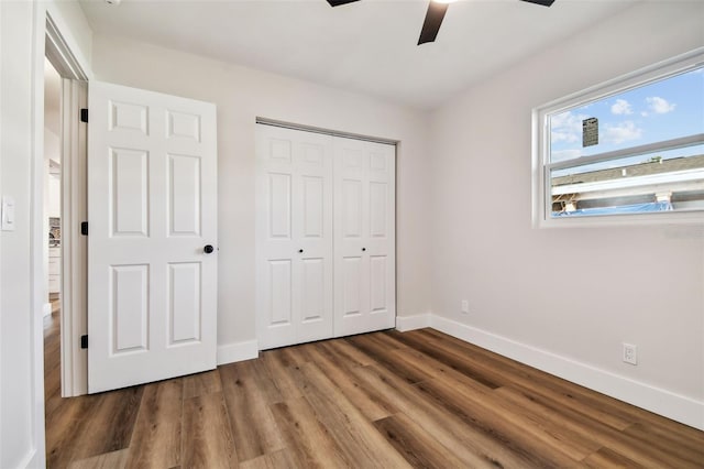 unfurnished bedroom featuring a closet, dark hardwood / wood-style floors, and ceiling fan