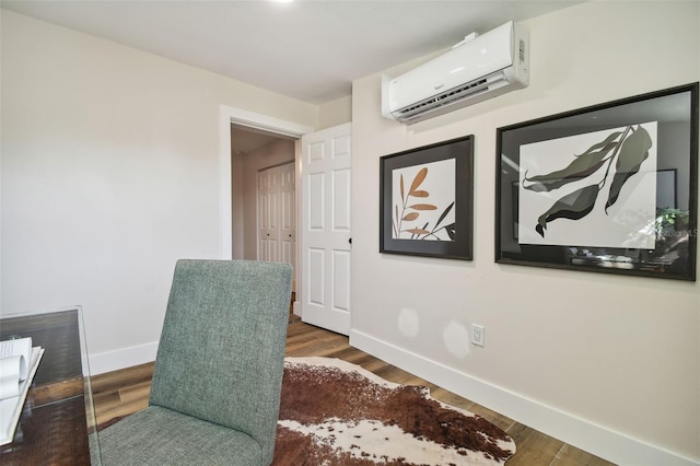 sitting room with dark hardwood / wood-style flooring and a wall unit AC