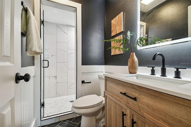 bathroom featuring vanity, toilet, and a shower with shower door