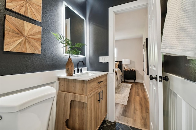 bathroom with hardwood / wood-style floors, toilet, and vanity