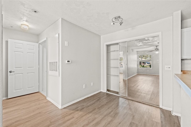 interior space featuring a textured ceiling and light hardwood / wood-style floors