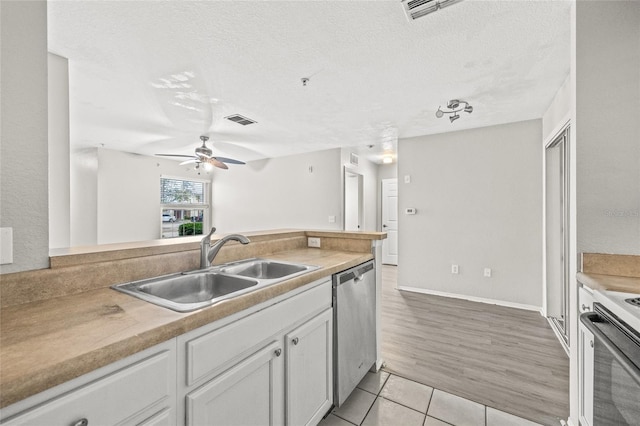 kitchen featuring white cabinets, stainless steel appliances, a textured ceiling, and light hardwood / wood-style floors