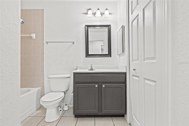 full bathroom featuring tile patterned floors, tiled shower / bath, vanity, and toilet