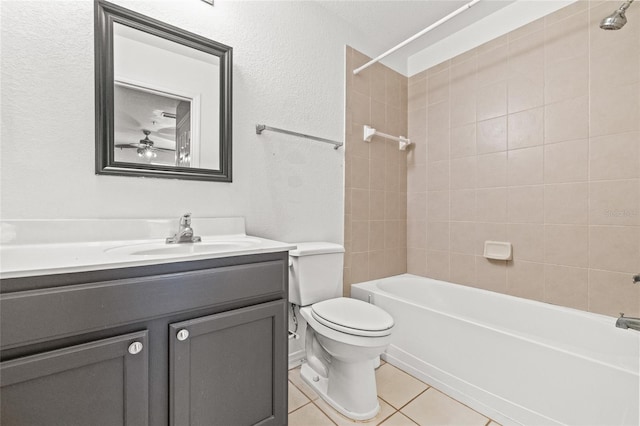 full bathroom featuring tile patterned floors, vanity, tiled shower / bath combo, ceiling fan, and toilet