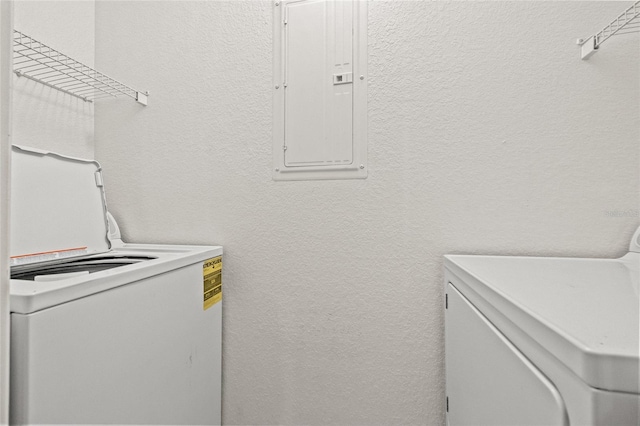 clothes washing area featuring electric panel and washing machine and dryer