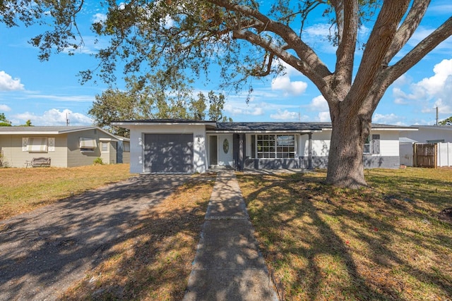 ranch-style house with a garage and a front lawn