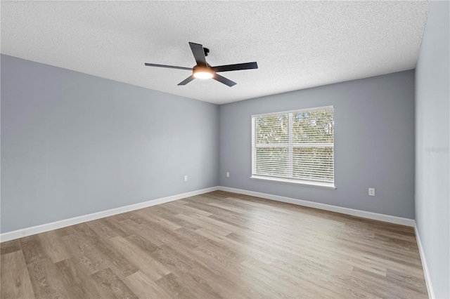 unfurnished room with ceiling fan, a textured ceiling, and light wood-type flooring