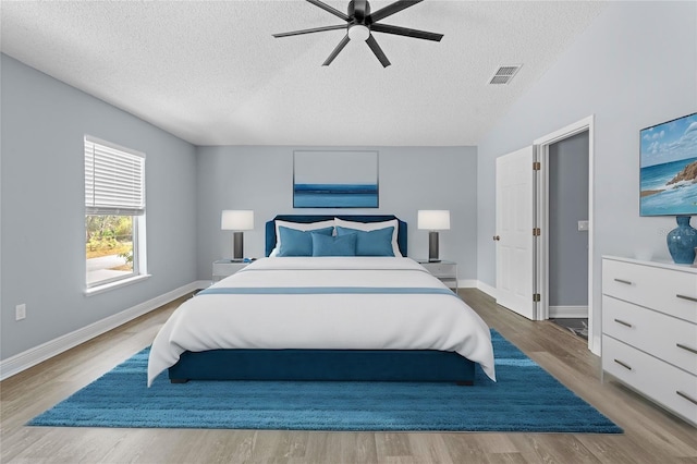 bedroom with ceiling fan, a textured ceiling, and hardwood / wood-style flooring