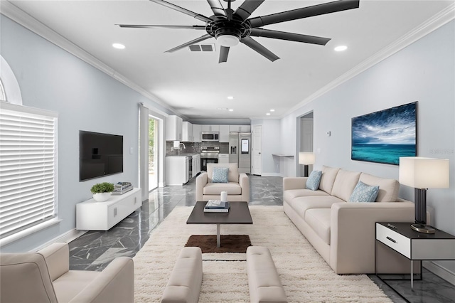 living room with ceiling fan, ornamental molding, and sink