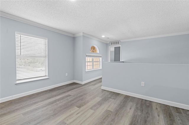 unfurnished room featuring light hardwood / wood-style floors, a textured ceiling, and ornamental molding