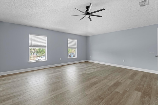 spare room with ceiling fan, wood-type flooring, and a textured ceiling