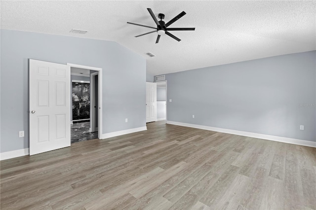 interior space featuring a textured ceiling, hardwood / wood-style flooring, vaulted ceiling, and ceiling fan