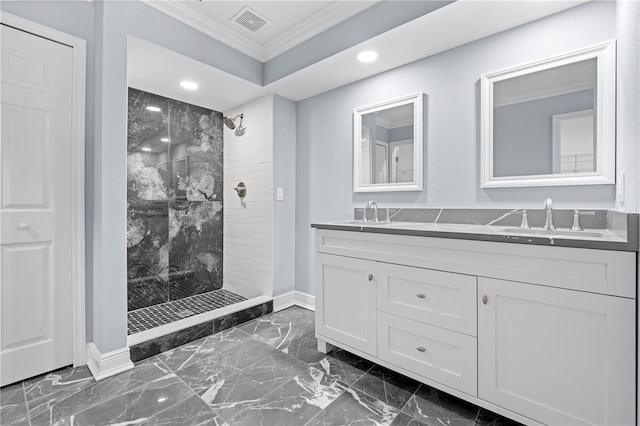 bathroom with vanity, a tile shower, and ornamental molding