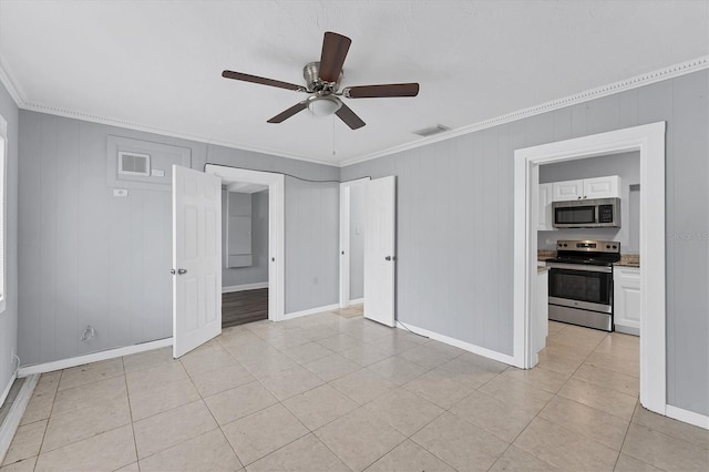 tiled spare room with wooden walls, ceiling fan, and crown molding