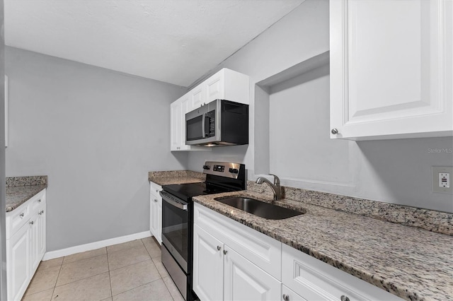 kitchen featuring white cabinets, stainless steel appliances, stone counters, and sink