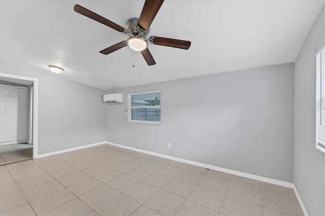 spare room with a wall mounted air conditioner, ceiling fan, and light tile patterned flooring