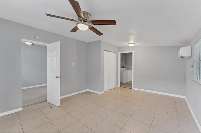 tiled empty room with washer / clothes dryer, ceiling fan, and a wall mounted air conditioner