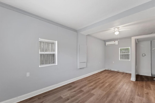 spare room with wood-type flooring, a wall unit AC, ceiling fan, and crown molding