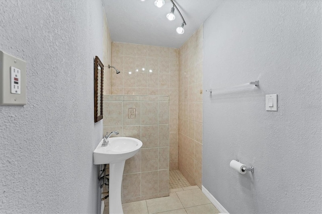 bathroom with a tile shower and tile patterned flooring