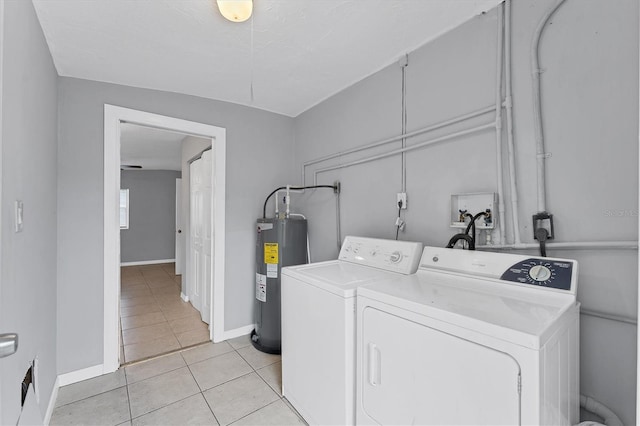 clothes washing area featuring water heater, light tile patterned floors, and independent washer and dryer