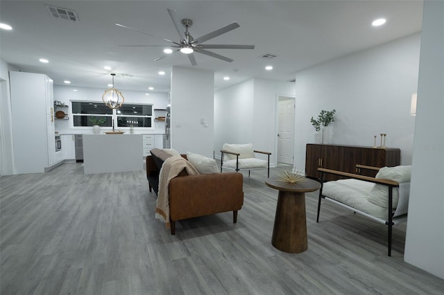 living room featuring ceiling fan and light hardwood / wood-style floors