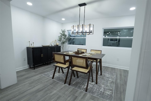 dining space with dark hardwood / wood-style flooring and an inviting chandelier