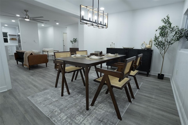 dining room featuring ceiling fan with notable chandelier and dark hardwood / wood-style flooring