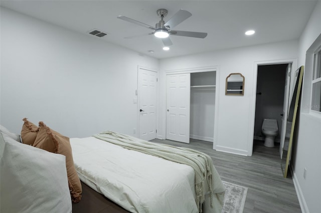 bedroom with hardwood / wood-style floors, a closet, ensuite bath, and ceiling fan