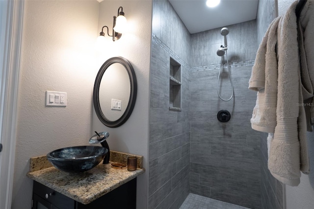 bathroom featuring vanity and tiled shower