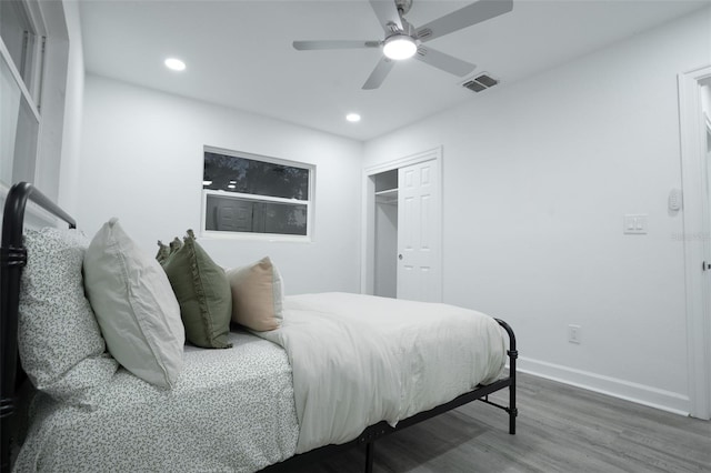 bedroom with hardwood / wood-style floors, ceiling fan, and a closet