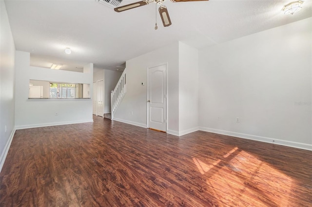 unfurnished living room featuring dark hardwood / wood-style floors, ceiling fan, and a textured ceiling