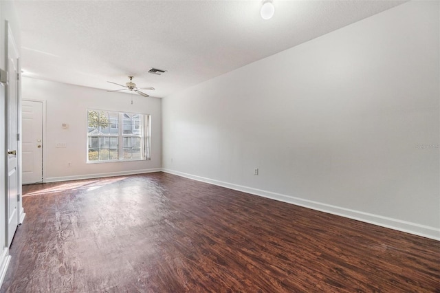 unfurnished room with ceiling fan, dark wood-type flooring, and a textured ceiling