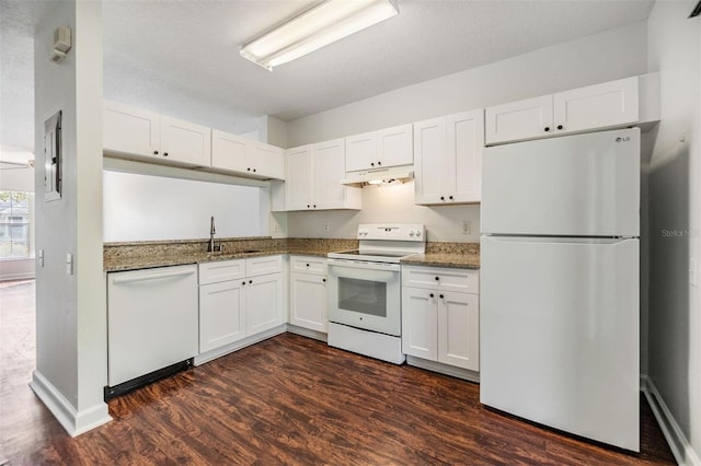 kitchen with white appliances, dark hardwood / wood-style floors, white cabinetry, and dark stone counters