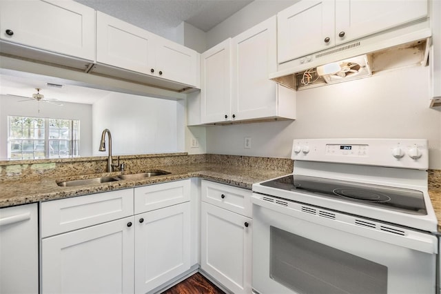 kitchen featuring electric range, white cabinetry, dark stone countertops, and sink