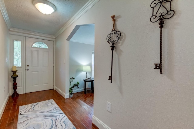 entryway with dark hardwood / wood-style floors, ornamental molding, and a textured ceiling