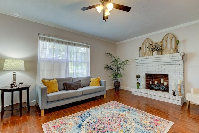 living room with hardwood / wood-style flooring, a fireplace, ceiling fan, and crown molding