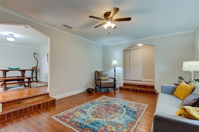 living room with ceiling fan, ornamental molding, and hardwood / wood-style flooring