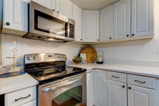 kitchen with white cabinets, decorative backsplash, and stainless steel appliances