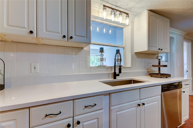 kitchen featuring hardwood / wood-style floors, dishwasher, white cabinets, sink, and decorative backsplash