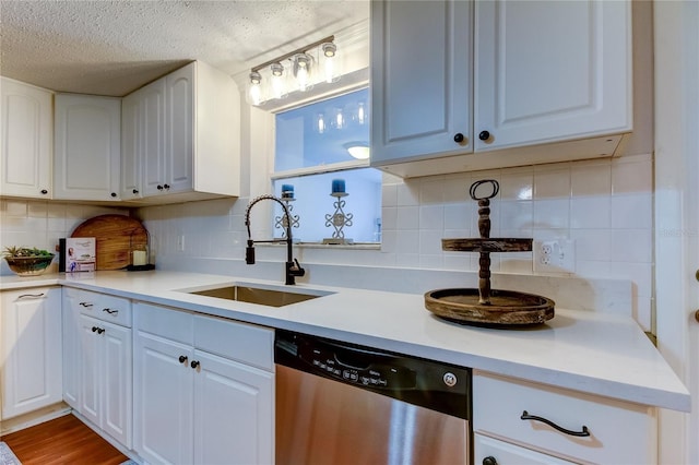 kitchen with dishwasher, wood-type flooring, white cabinets, and sink