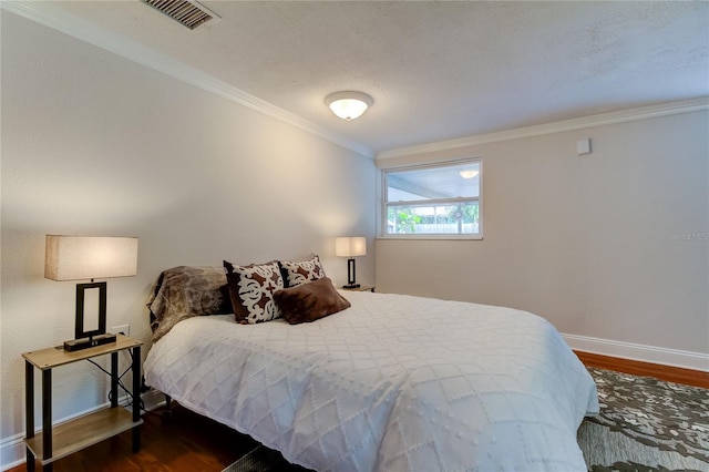 bedroom featuring crown molding and dark hardwood / wood-style flooring