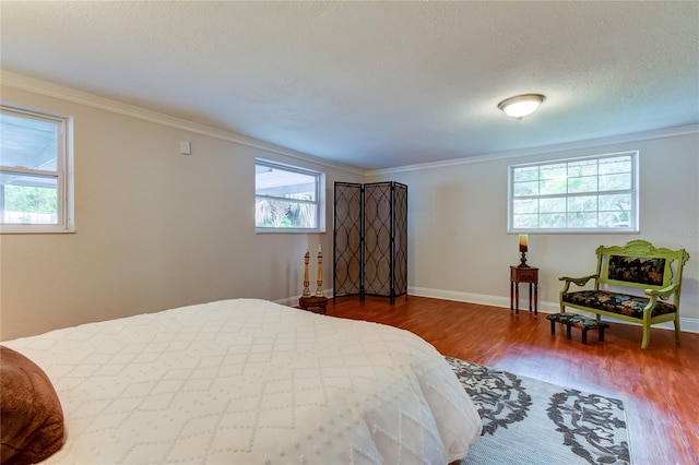 bedroom with hardwood / wood-style flooring, multiple windows, and ornamental molding